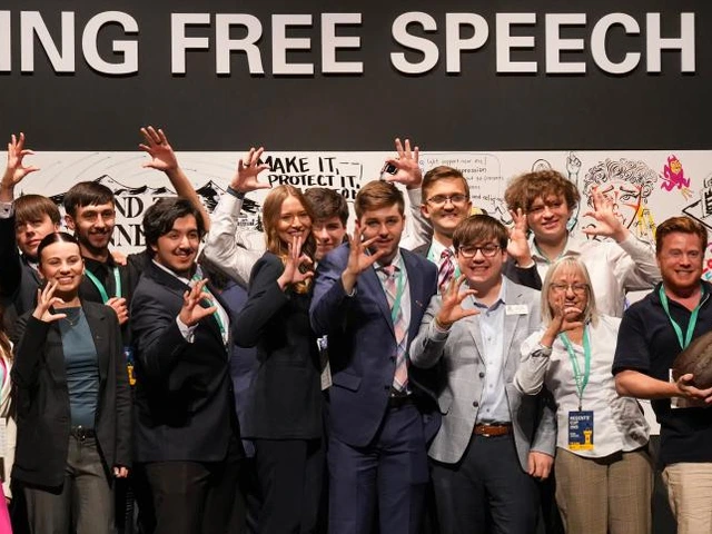 Group of students and faulty stand in a group, one person hold the Regents Cup award