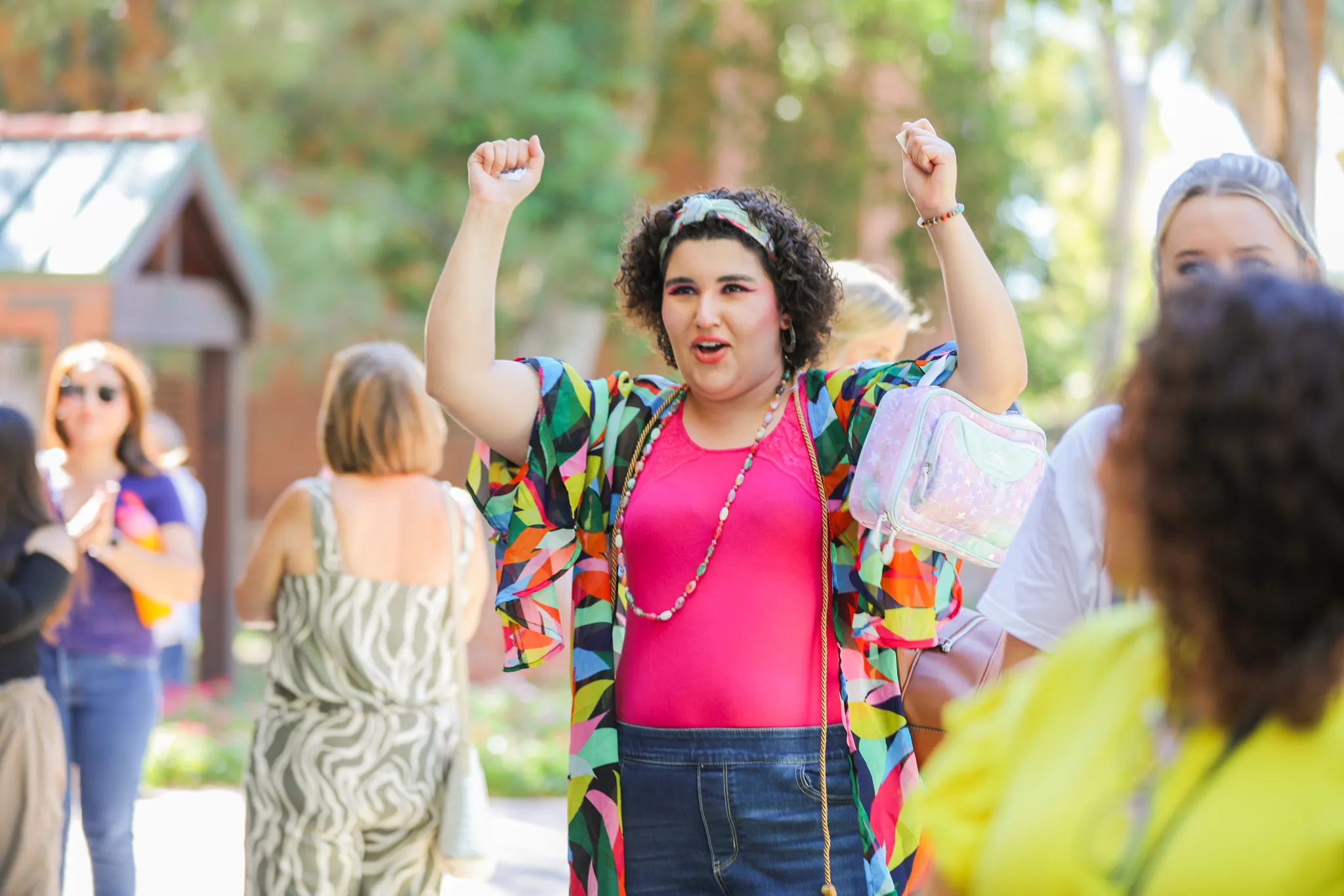 woman in pink shirt with hands up at honors ceremony