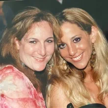 Two women sit together smiling