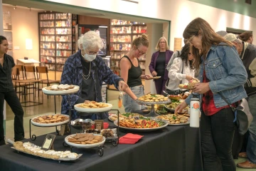 People getting food at a reception table
