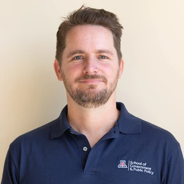 Man with dark blonde hair and wearing a blue UA shirt