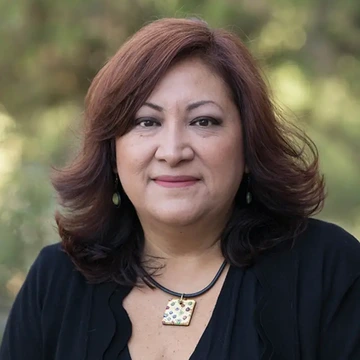 Woman with long auburn hair, outside, smiling