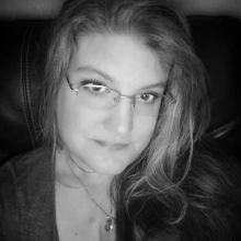 Black and white photo of a woman with long hear and wearing glasses