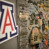 A wall with an "A" logo and also military-related pins, medals, badges and patched