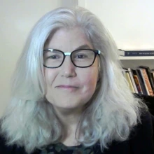 Woman with white hair and dark glasses