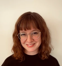 Woman with glasses and wearing a black shirt