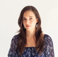 Woman with long brown hair wearing a blue flowered top