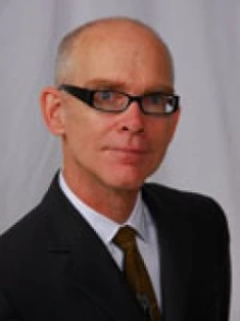 Man wearing a black suit and wearing black glasses